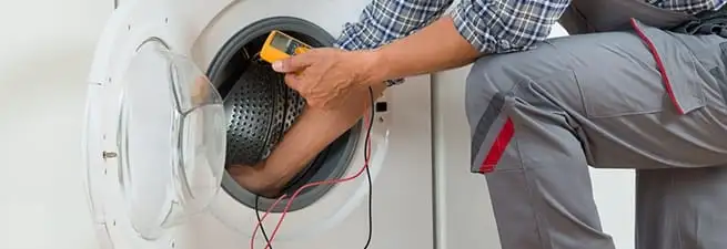 Dryer repair technician inspecting and repairing a clothes dryer in Bradenton, FL