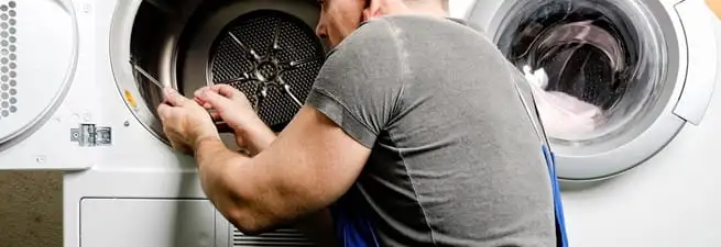 Dryer repair technician fixing a clothes dryer drum in Bradenton, FL