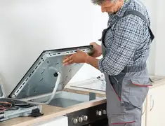 Appliance repair technician installing a built-in cooktop in Bradenton, FL