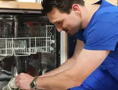 Dishwasher repair technician inspecting and servicing an open dishwasher in Bradenton, FL