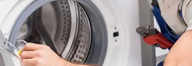 Appliance technician repairing a clothes dryer drum and internal parts in Bradenton, FL