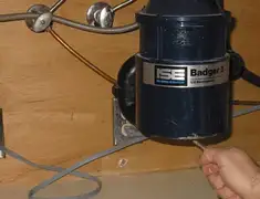Garbage disposal repair technician tightening the mounting ring under a sink in Bradenton, FL