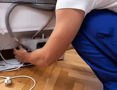 Appliance repair technician fixing refrigerator water line and connections in Bradenton, FL