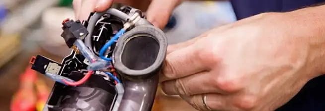 Vacuum repair technician reconnecting wiring and components in Bradenton, FL
