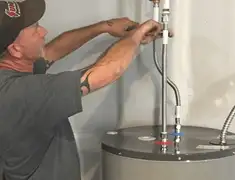 Water heater repair technician tightening supply line connections in Bradenton, FL
