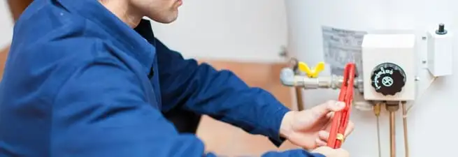 Water heater repair technician adjusting the temperature control and gas valve in Bradenton, FL